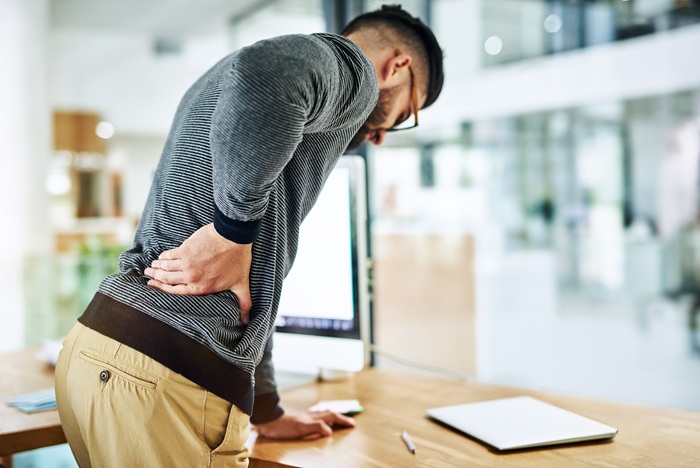 Office man suffering Sciatica pain during work