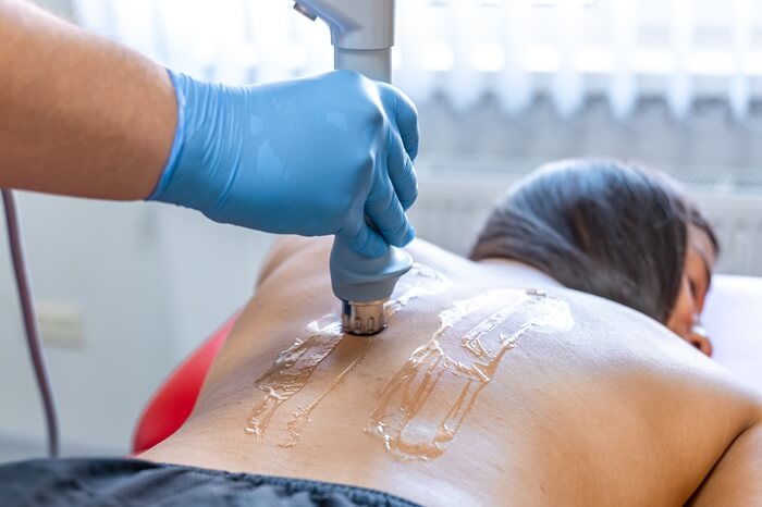 fit women under shockwave therapy treatment