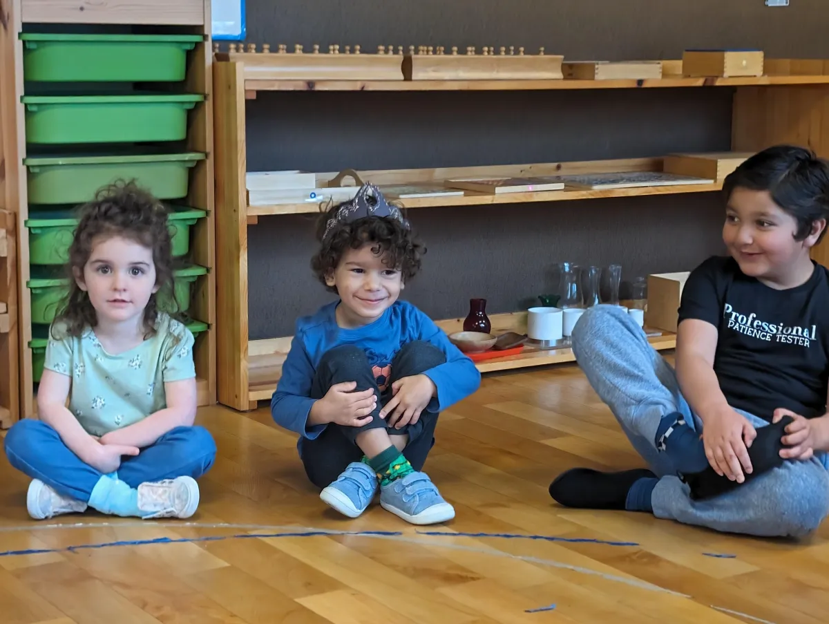 grayscale photography of teacher standing near chalkboard and children sitting on chairs