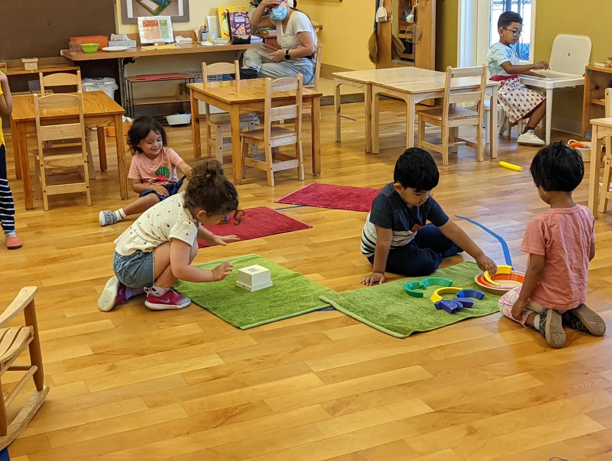 a woman standing in front of a group of children