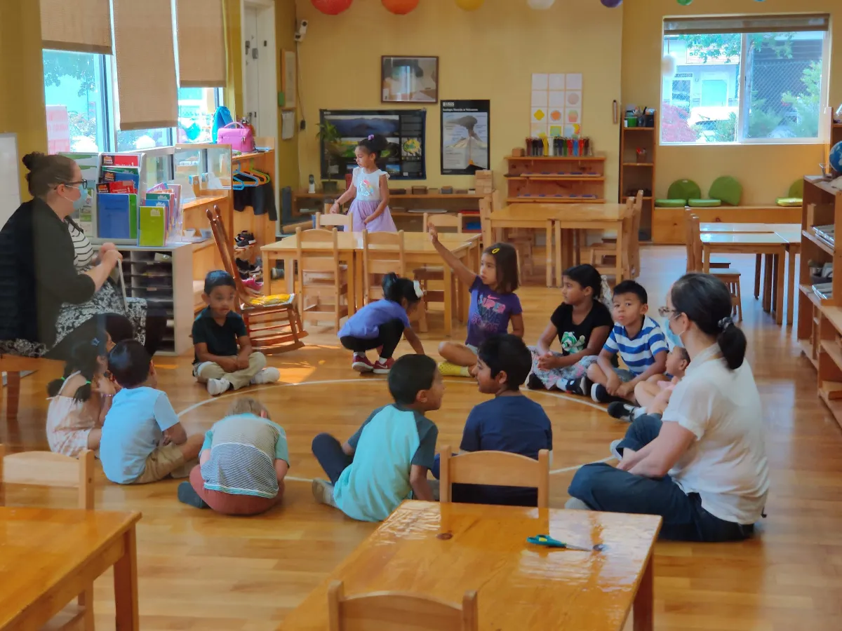 silhouette of child sitting behind tree during sunset