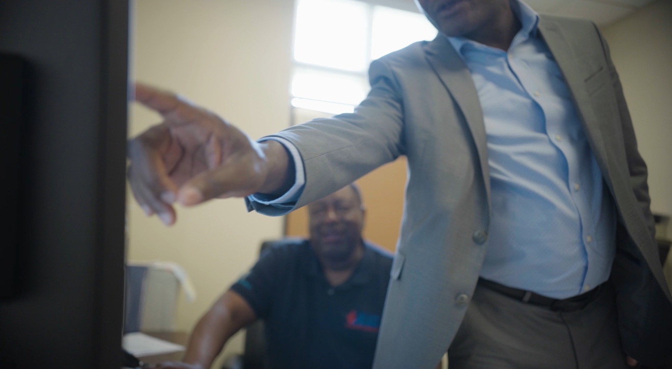 Modern building facade with green accents and trees.