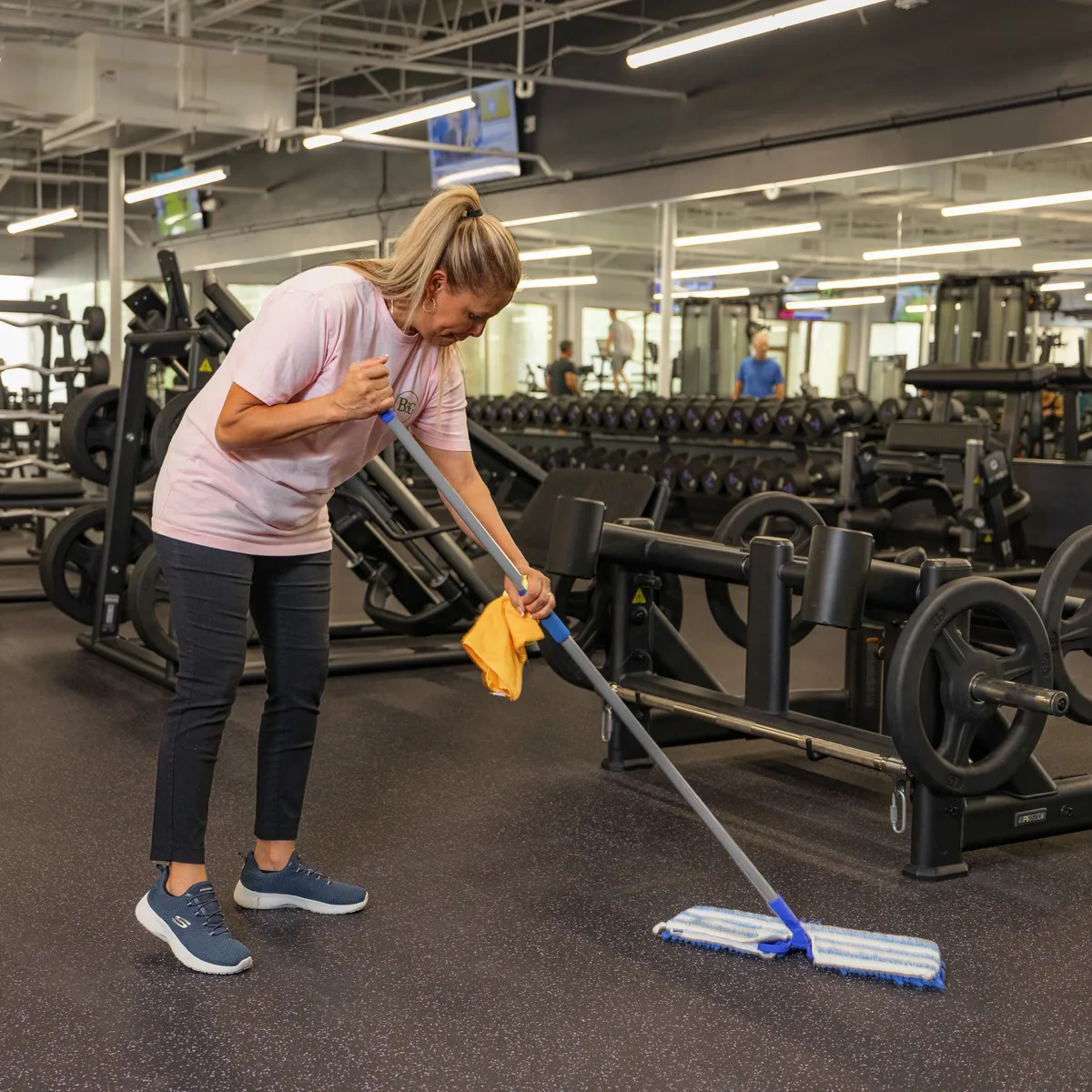 Bubbles & Grime team member mopping a commercial gym floor in Hilton Head, SC
