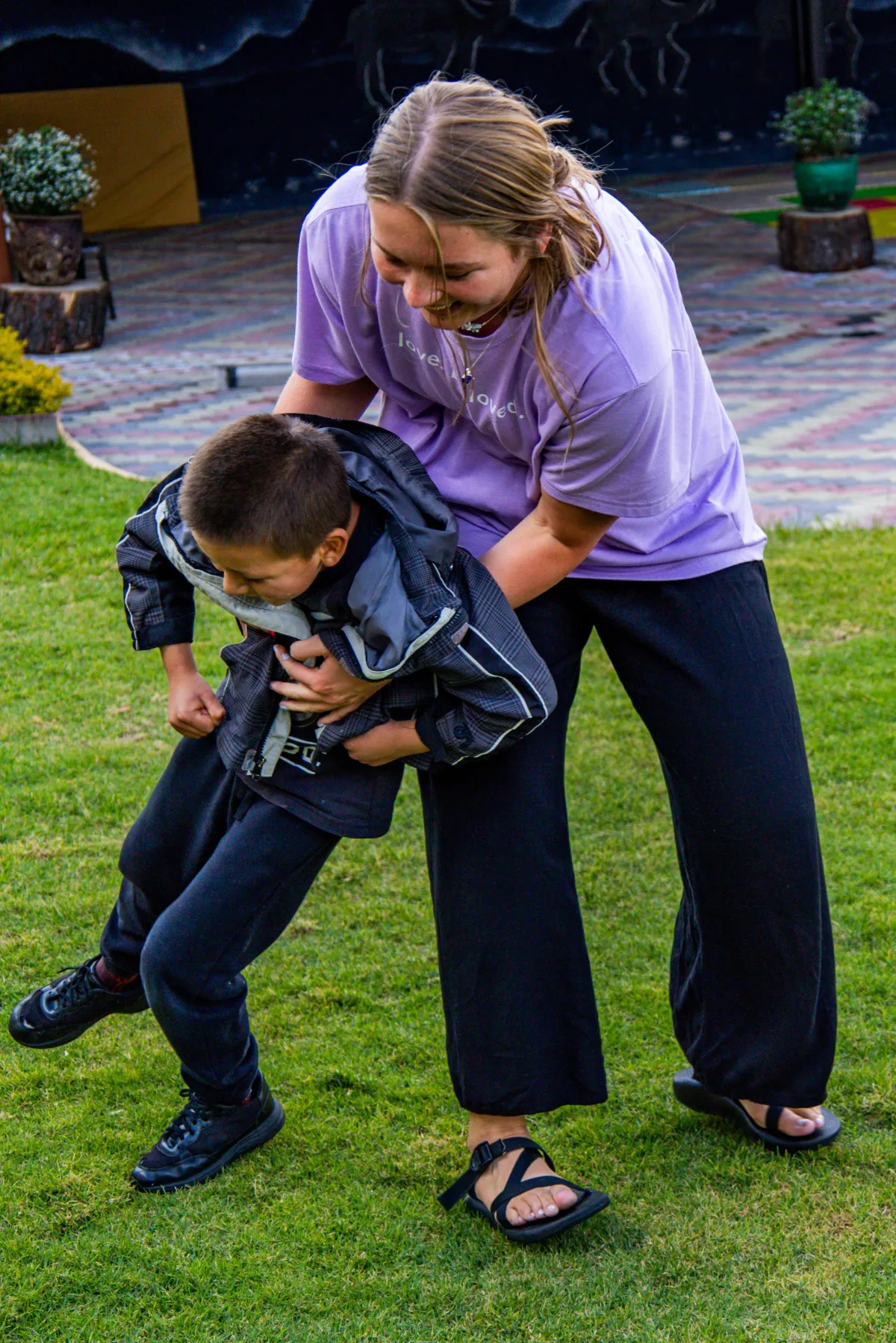volunteer and child walking a paved path