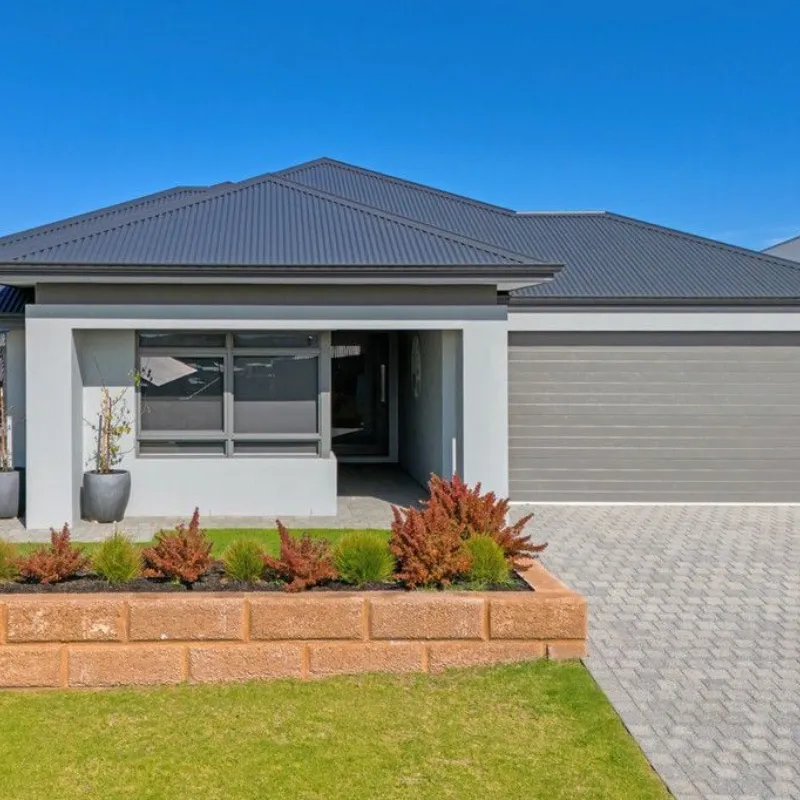 Modern family home with a landscaped front yard, featuring a gray facade and a double garage, showcasing successful property purchase results by Arin Russell Buyers Agents.