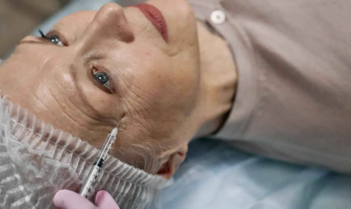 Woman getting injected towards her eye smile wrinkles