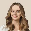 a woman with long hair is smiling for the camera