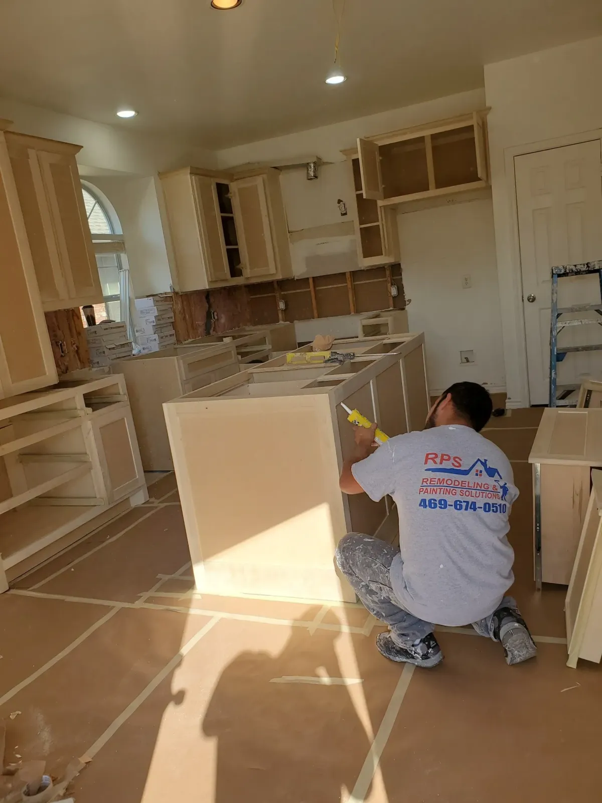 a man kneeling on the floor in a kitchen
