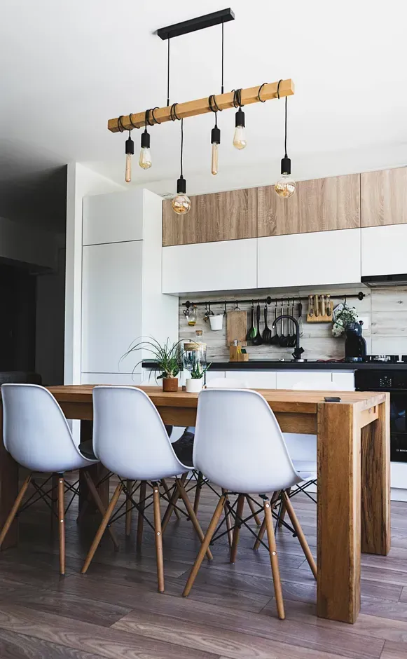 a kitchen with a wooden table and white chairs