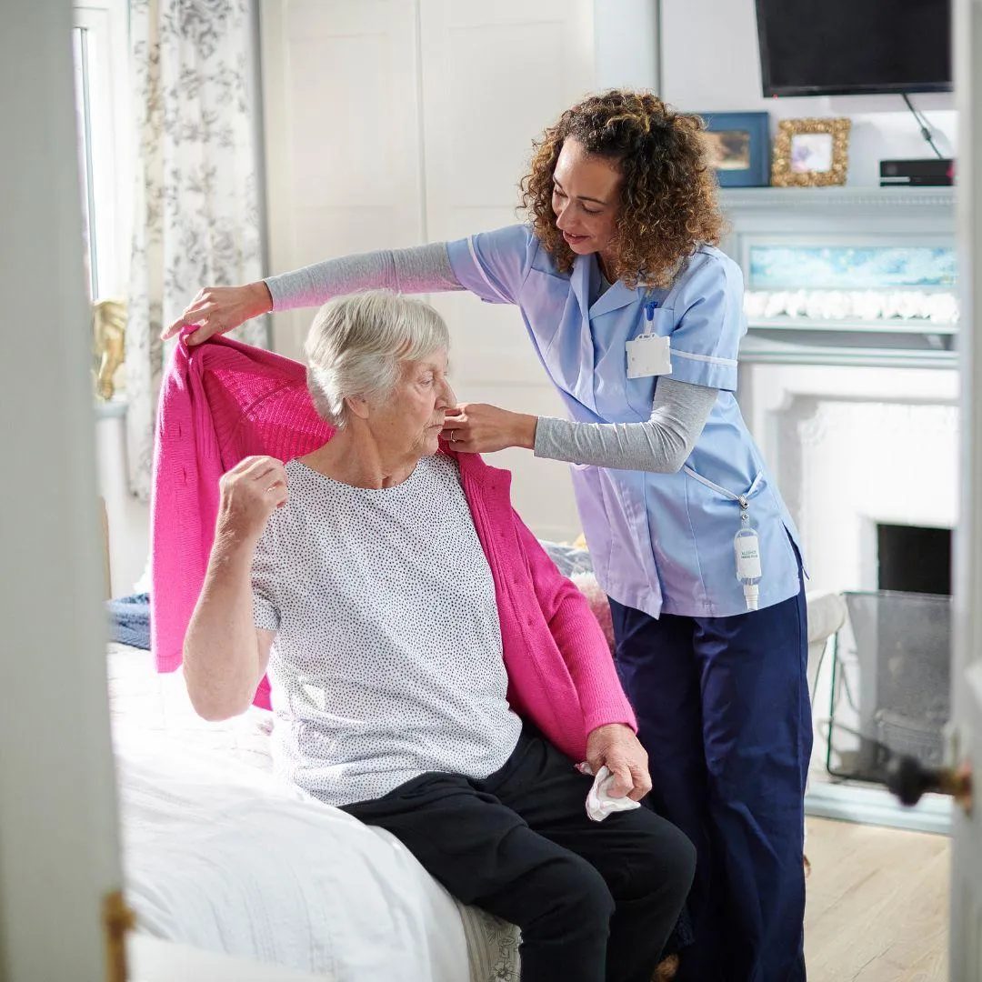 home health aide in vineland helping home health care patient put on a sweater