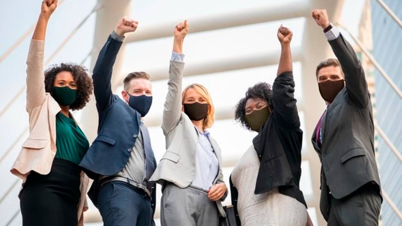 Masked colleagues working together toward shared goals.