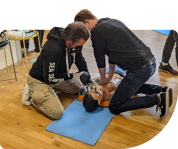 Deux hommes pratiquant une massage cardiaque sur un mannequin