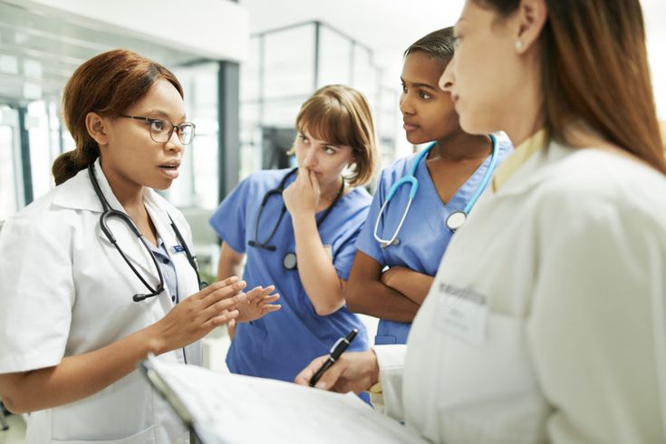 A diverse group of adults participates in a rooftop fitness class overlooking a modern city skyline. The group includes men and women of various ages, all engaged in dynamic movement. The cityscape glows in the morning sun, creating a vibrant, motivating urban wellness atmosphere.