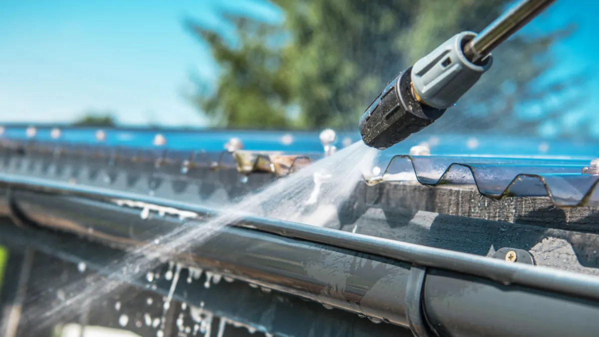 Water blaster cleaning out gutter