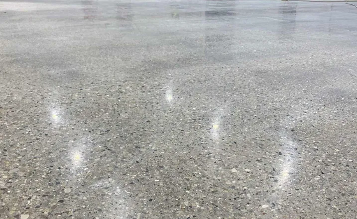Polished concrete floor showcasing a sleek, reflective surface with a clean, modern finish, ideal for high-traffic areas in residential and commercial spaces.
