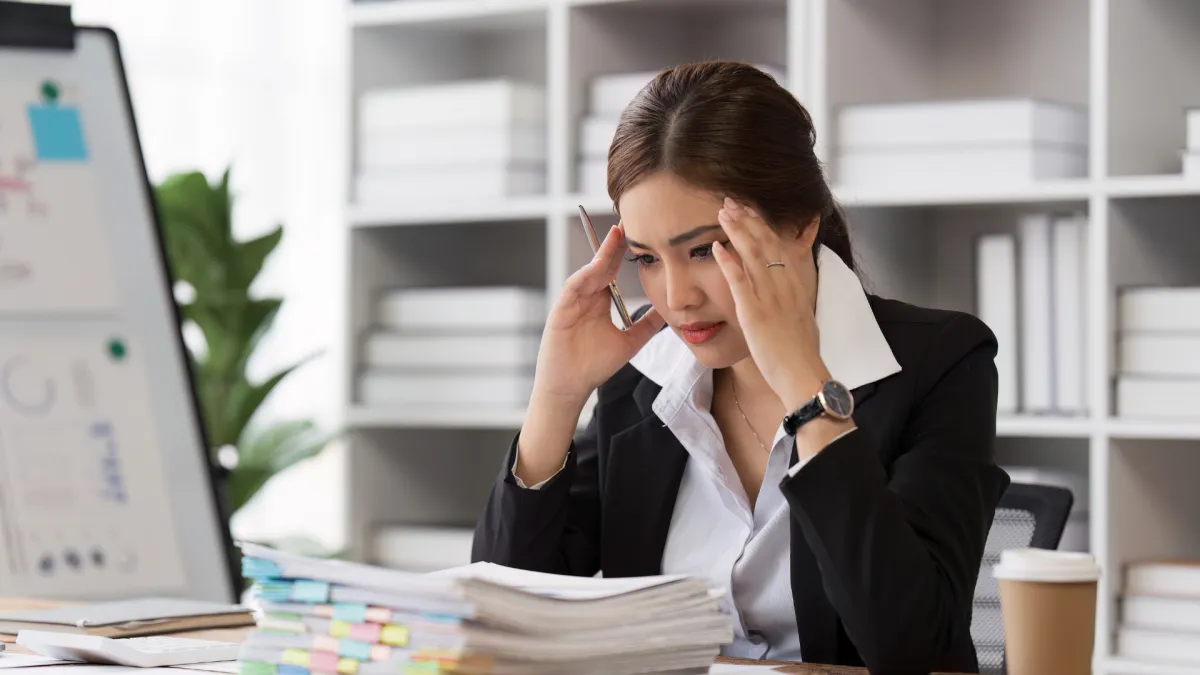 Business owner feeling overwhelmed while managing team operations and calls, representing the stress of founder dependency before Fractional COO support.
