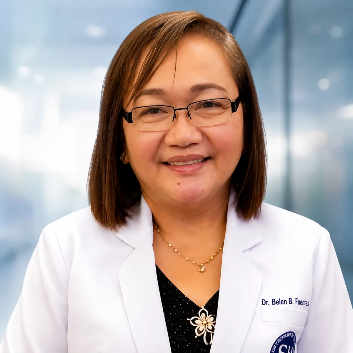 Pediatric dentist smiling in clinic with credentials in the background