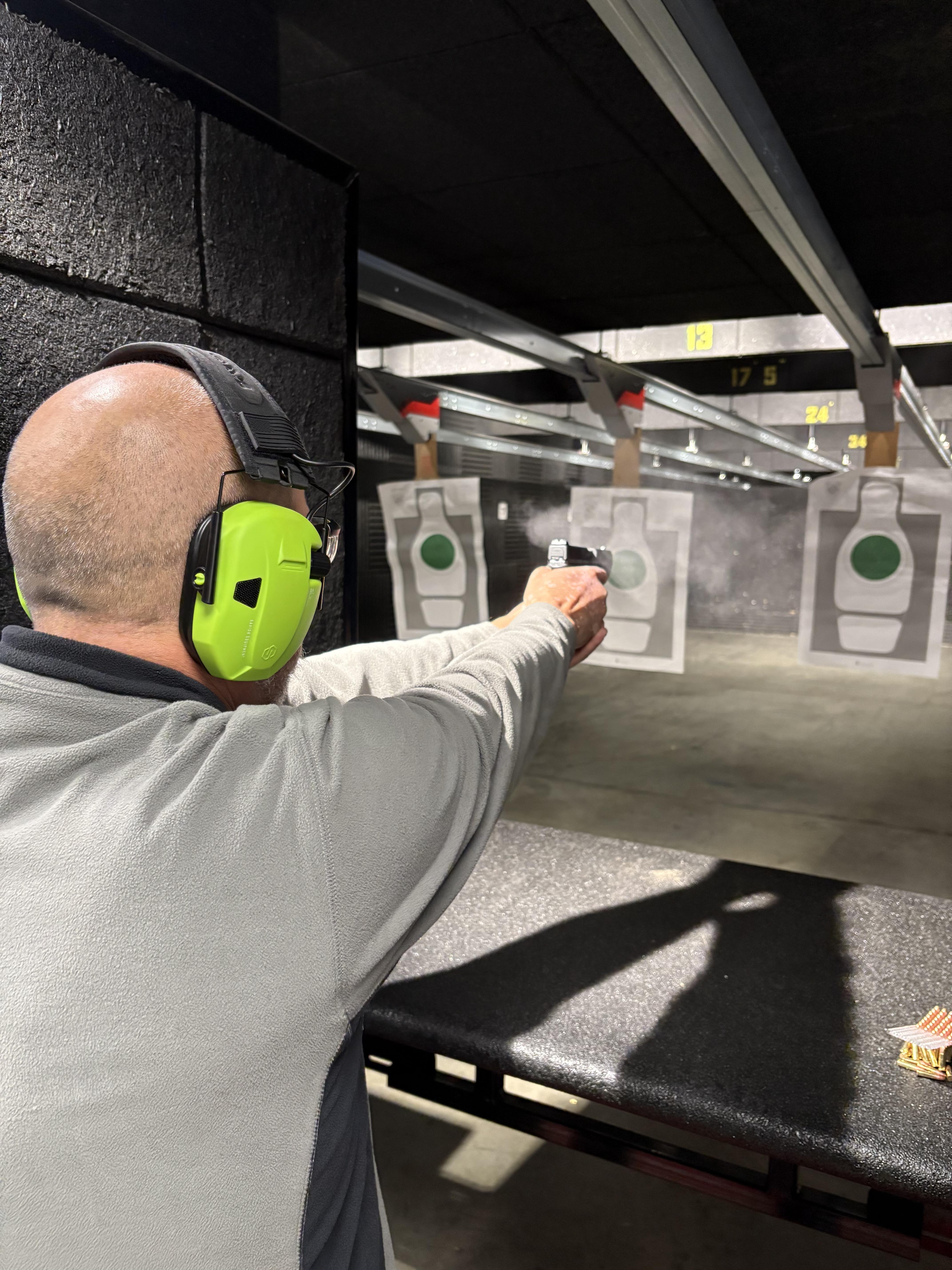 person in black and green camouflage jacket holding black rifle