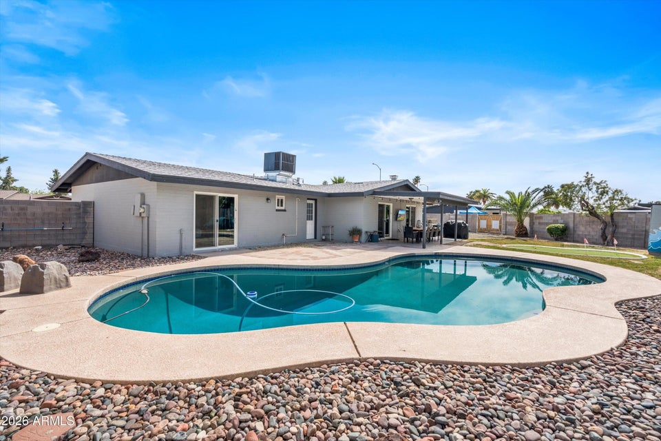 backyard with a bright blue pool and spa 