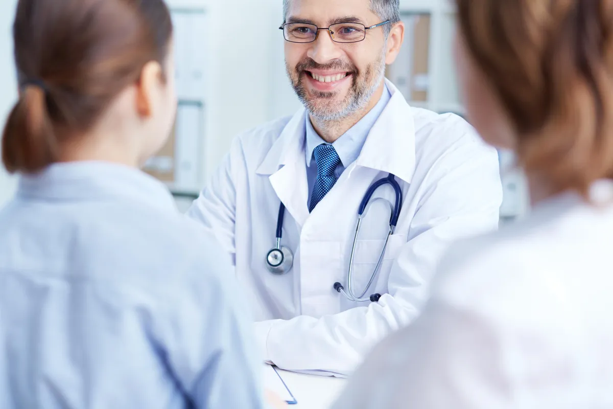 Doctor with stethoscope consulting with patient