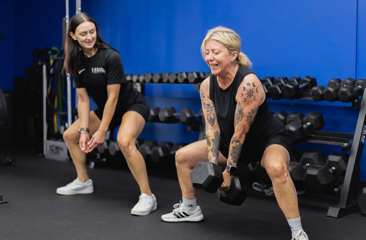 Coach and member doing a dumbbell squat at 1 Force