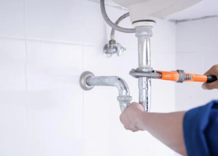 Plumber repairing a leaking sink in Bluffdale, UT.