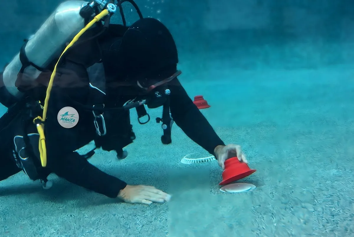 Manta Leak Detection diver inspecting a pool drain during an underwater leak inspection