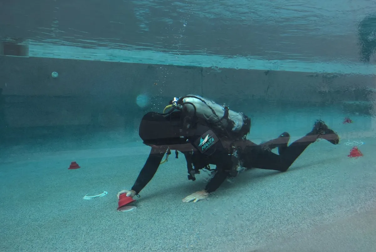 Diver inspecting a pool drain during a pre-purchase leak inspection
