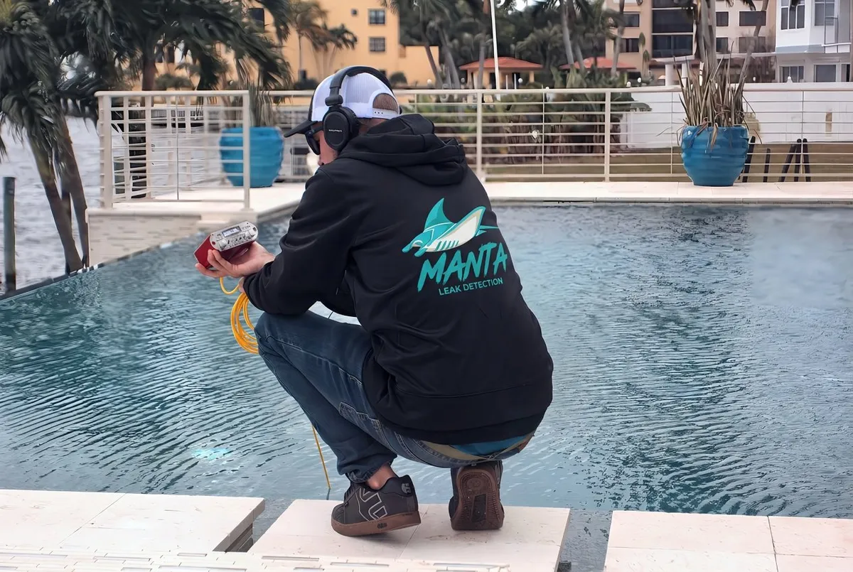 Manta Leak Detection technician performing acoustic leak detection at an infinity pool in Southwest Florida