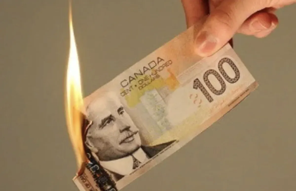 Picture of someone holding a $100 bill that is burning