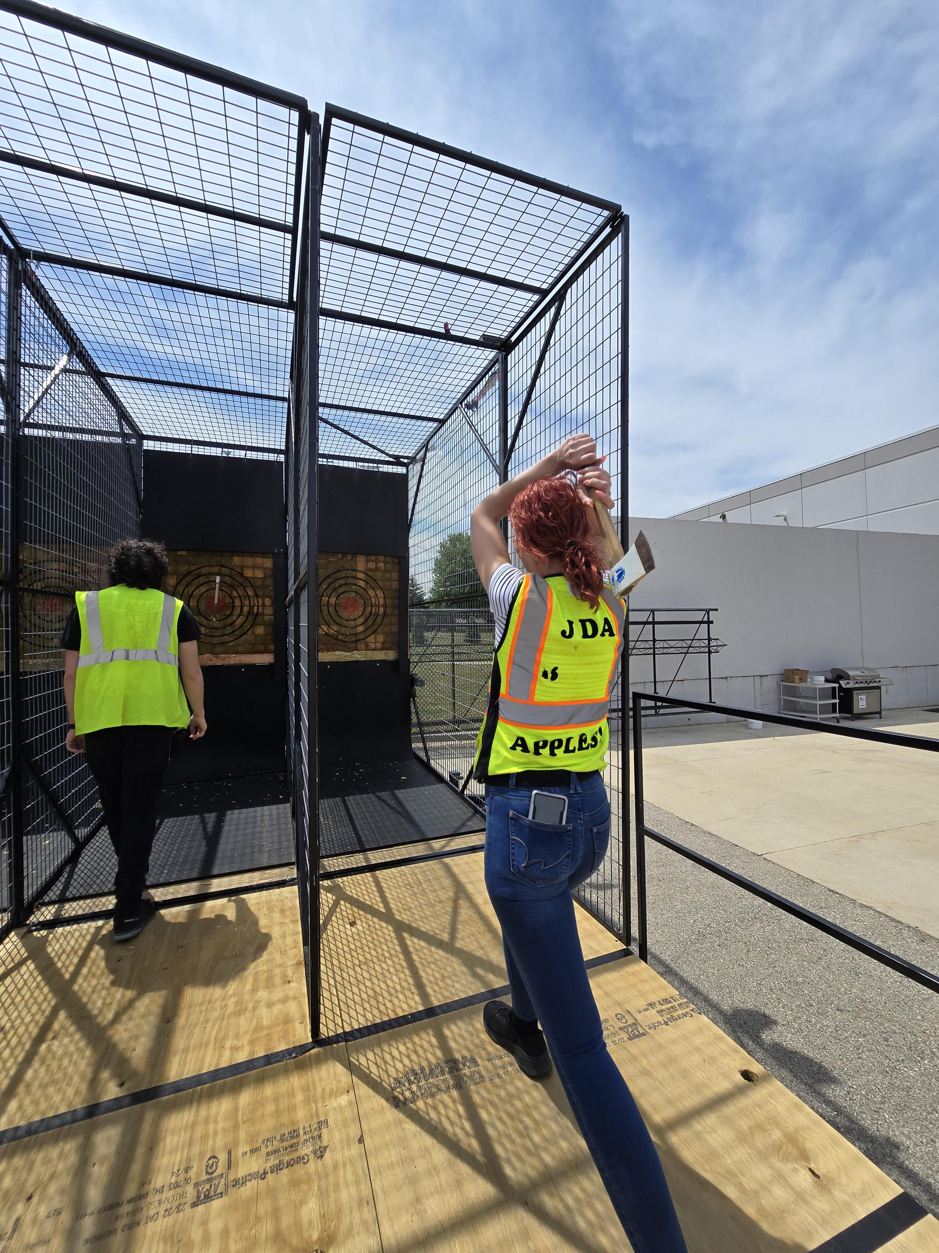 Guests throwing axes at Hold My Beer’s mobile axe throwing unit during a TEAM BUILDING EVENT