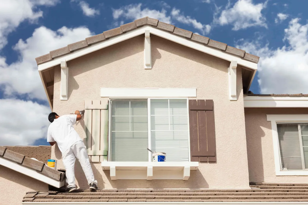 Painter painting outside of house