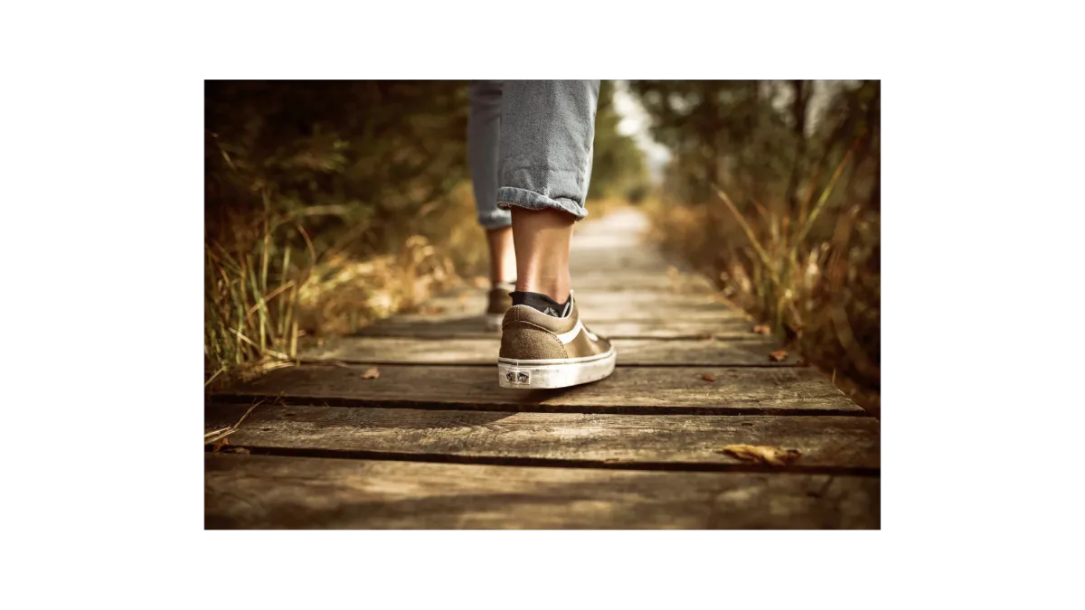 Photo of feet walking along a timber path