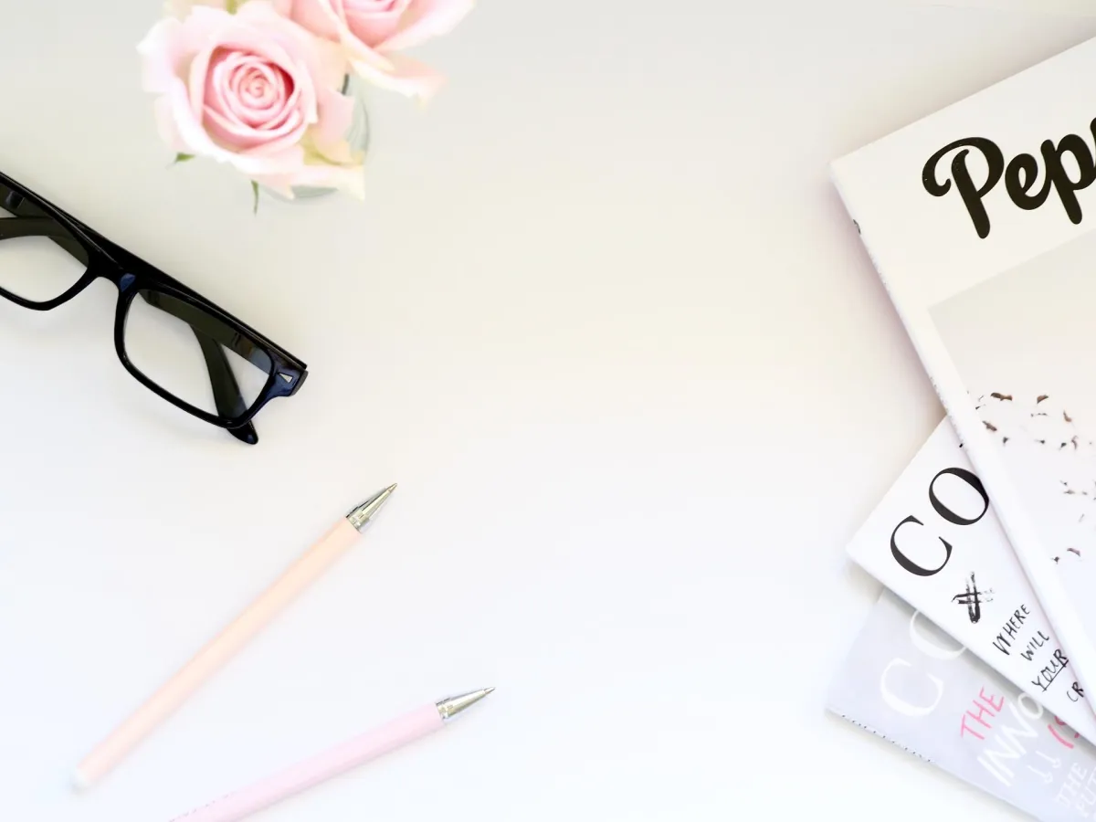 Contact Us Page with 2 Pens, Glasses and 3 Magazines on a Desk