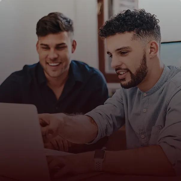 Two professionals reviewing business funding options on a laptop
