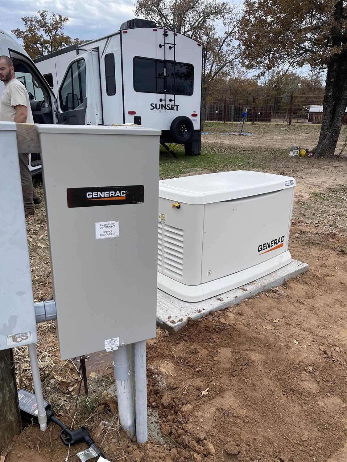 A Generac standby generator installed next to an electrical panel outdoors, with an RV parked in the background.