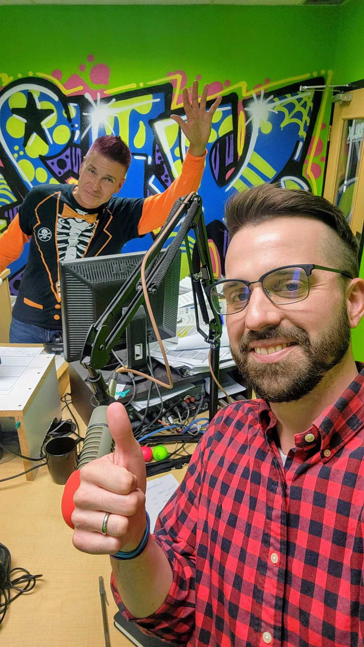 Portrait of Jeremy, a mid-40s radio producer holding a studio headset, smiling.