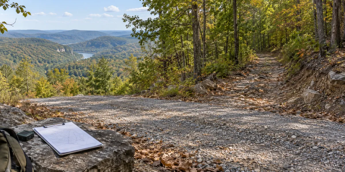 Gravel road approaching wooded rural land during a legal and physical access review.