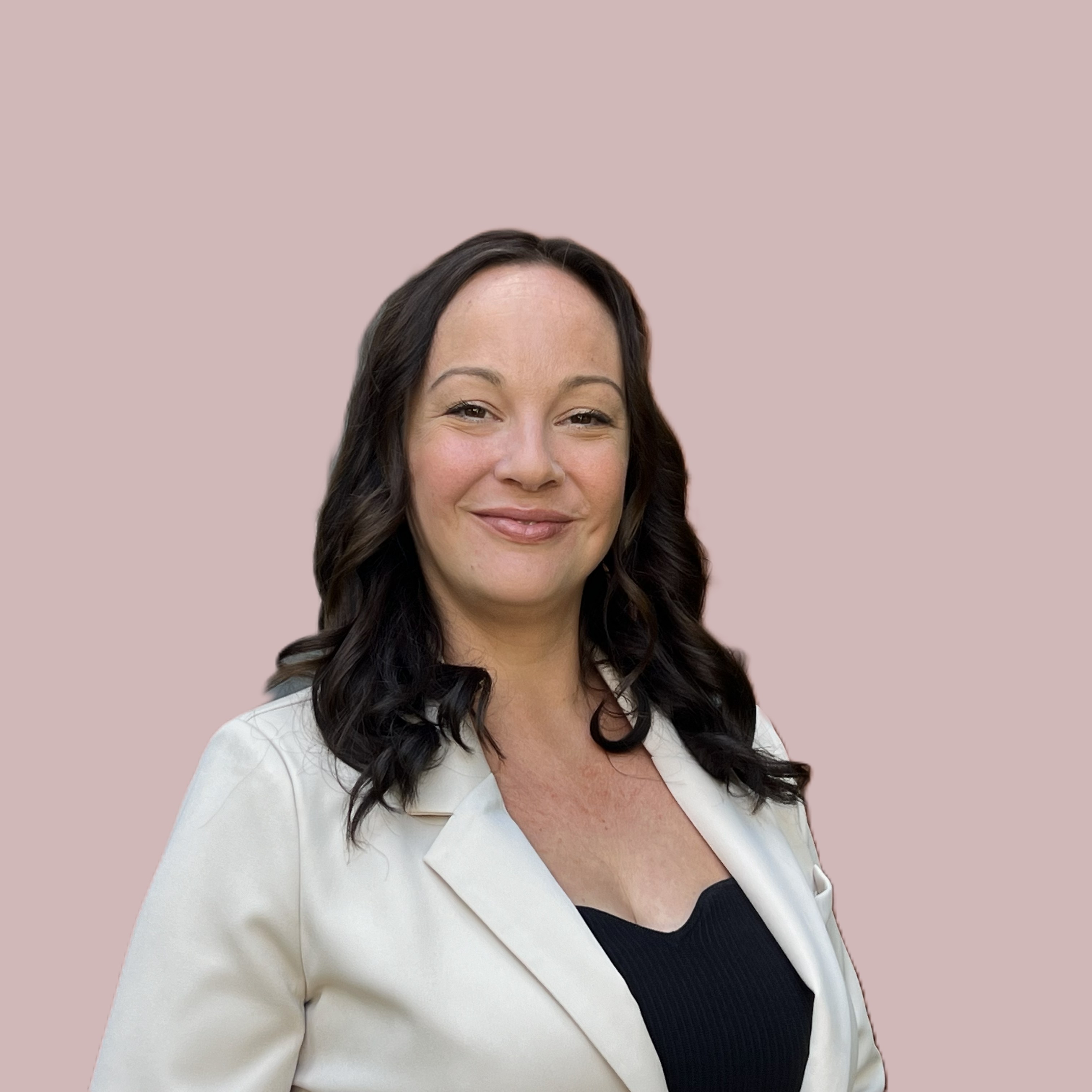 Amber, a compassionate woman with gentle eyes, sits cross-legged on a soft rug in a sunlit room, surrounded by calming decor and plants, radiating warmth and approachability.