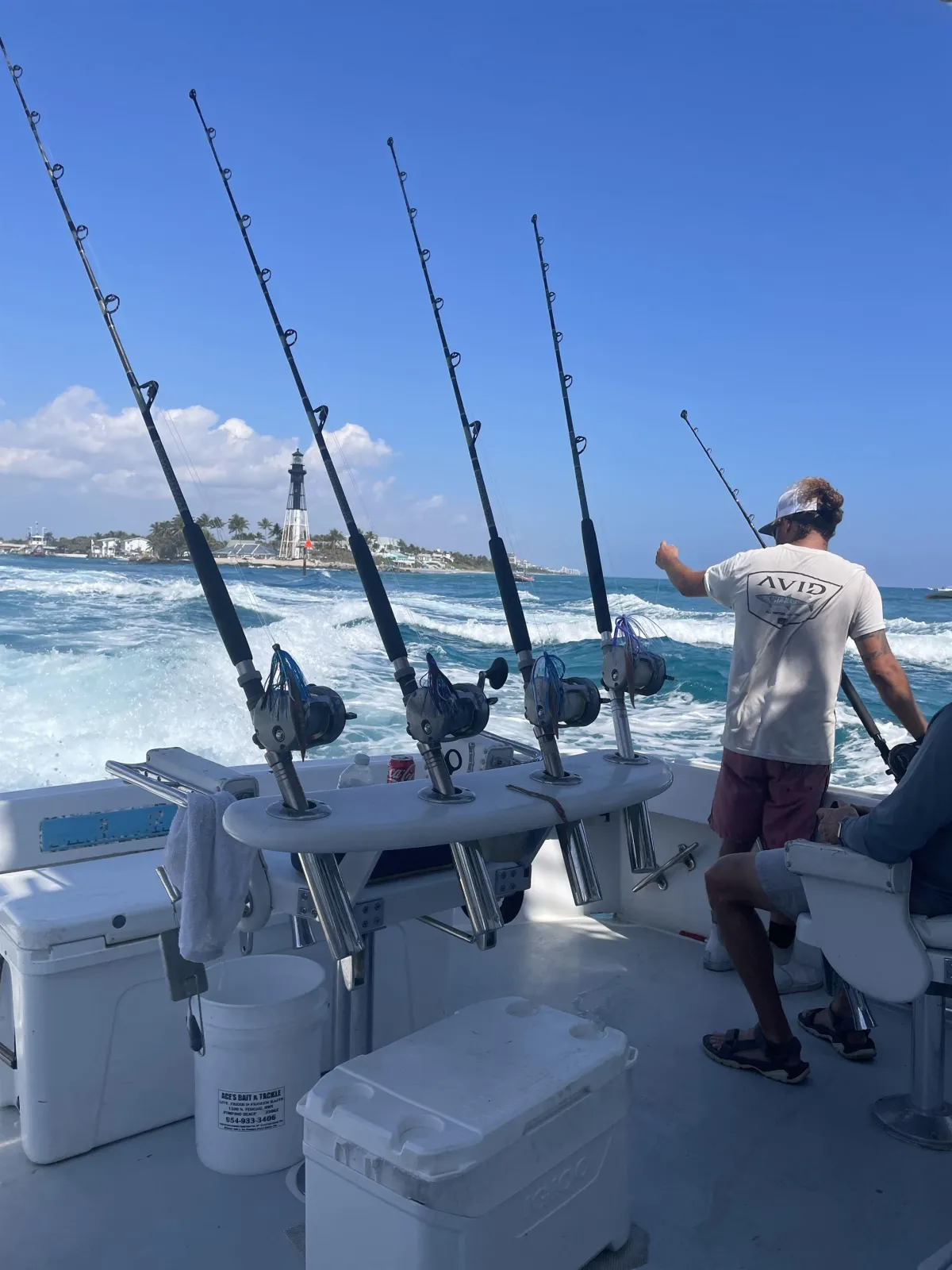 Killin Time charter boat cruising past Hillsboro Inlet Lighthouse with fishing rods ready