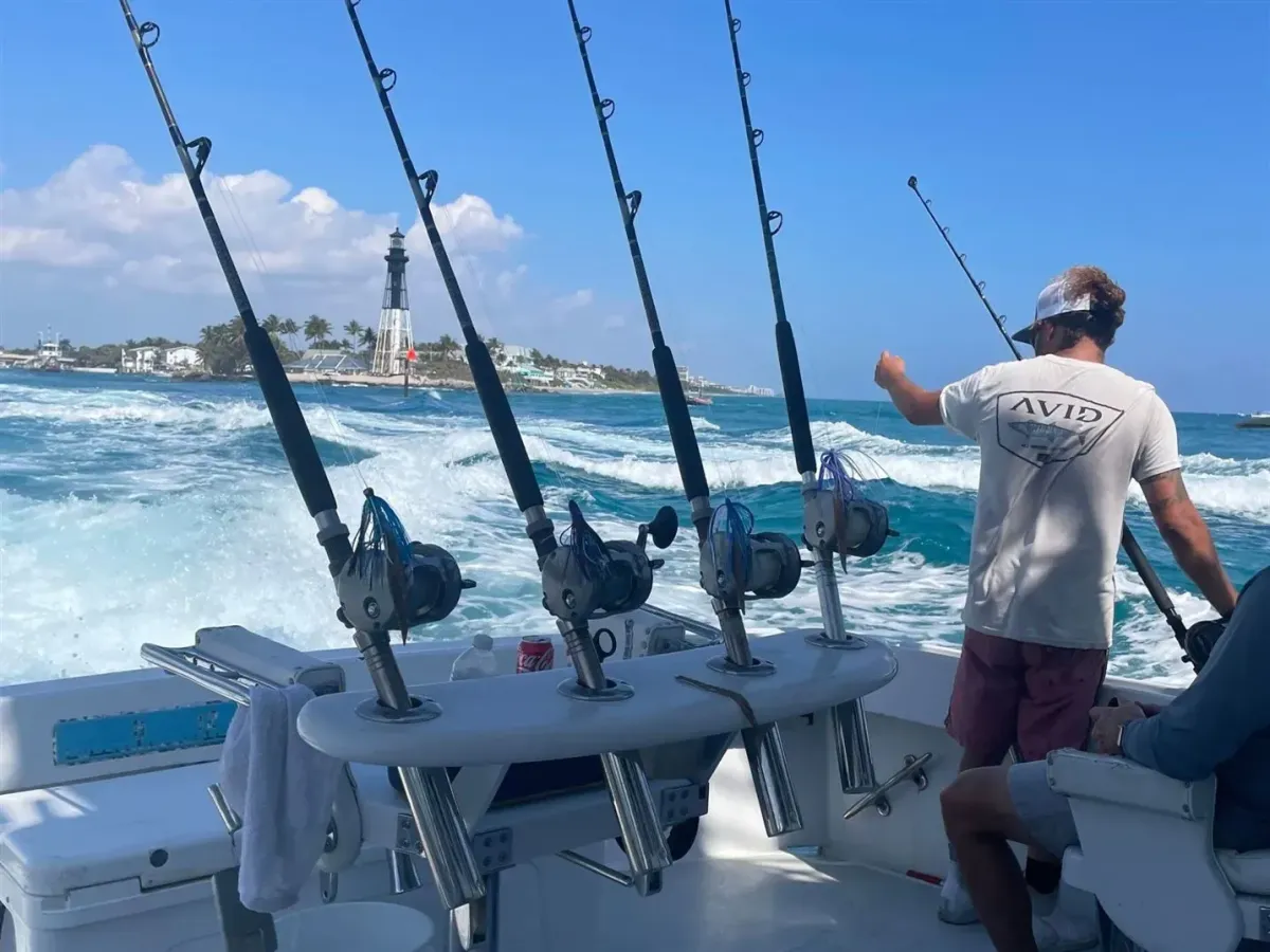 Killin Time charter boat cruising near the Hillsboro Inlet Lighthouse with fishing rods ready