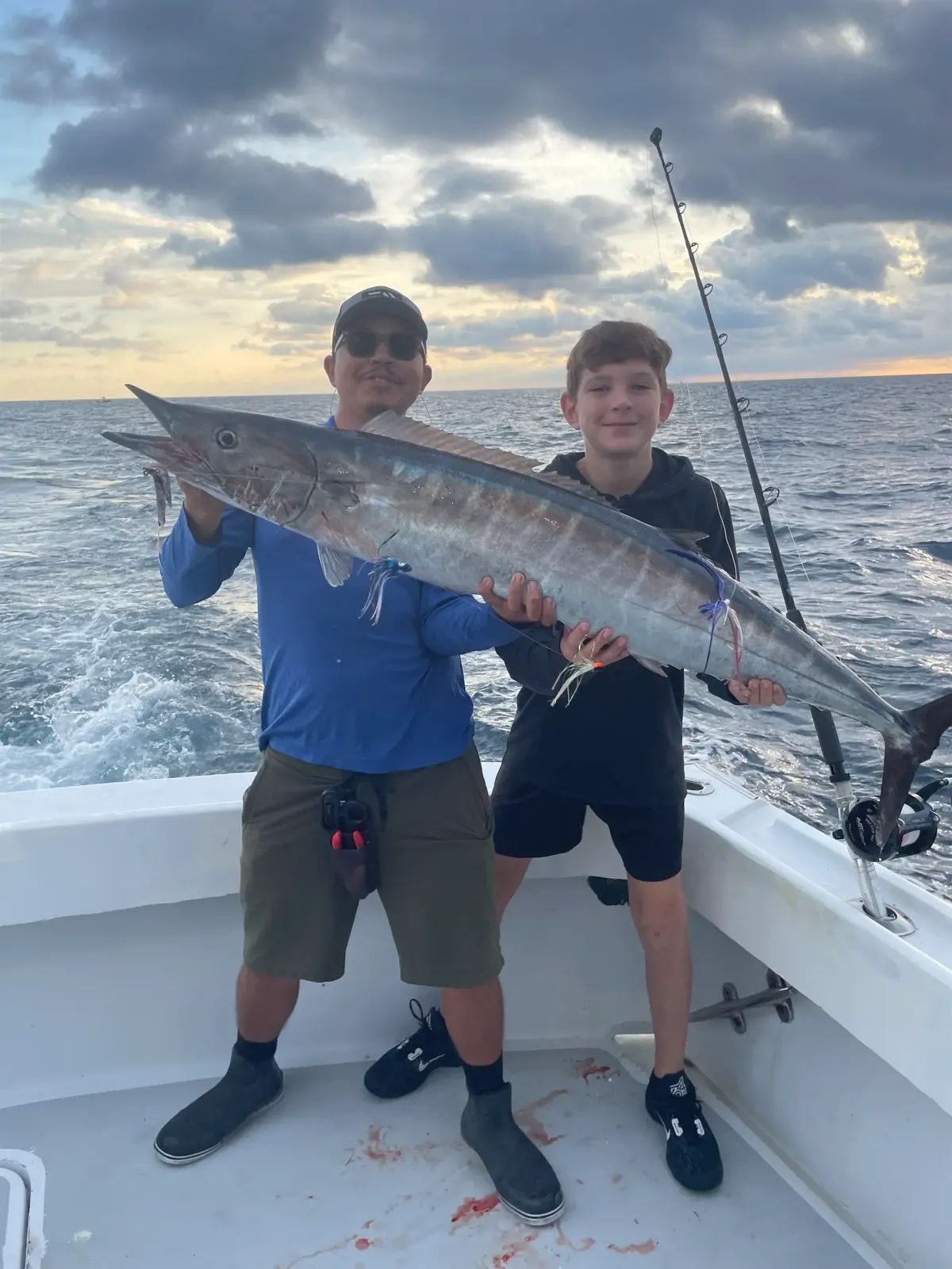 Anglers holding a large Wahoo caught on a sport fishing charter off Pompano Beach