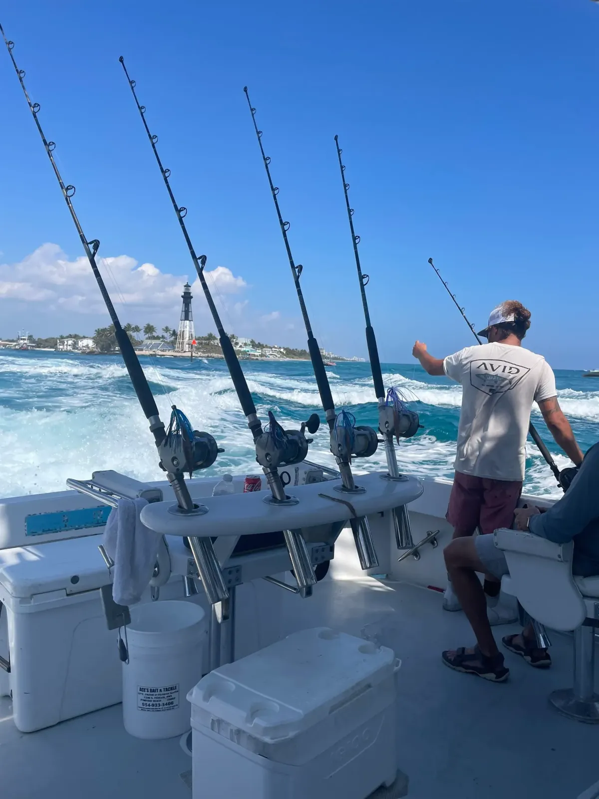 Killin Time charter boat cruising past Hillsboro Inlet Lighthouse with fishing rods ready