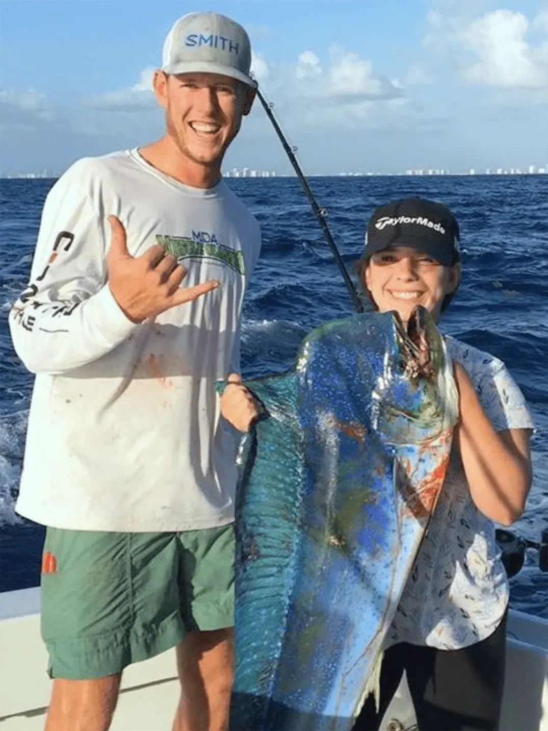 Anglers holding a large colorful Mahi Mahi dolphin fish caught on a summer charter