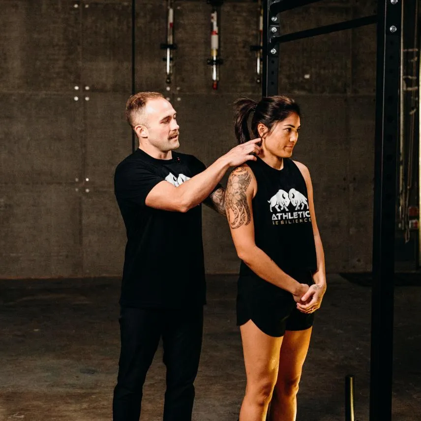 Clinician assessing an athlete's shoulder and neck