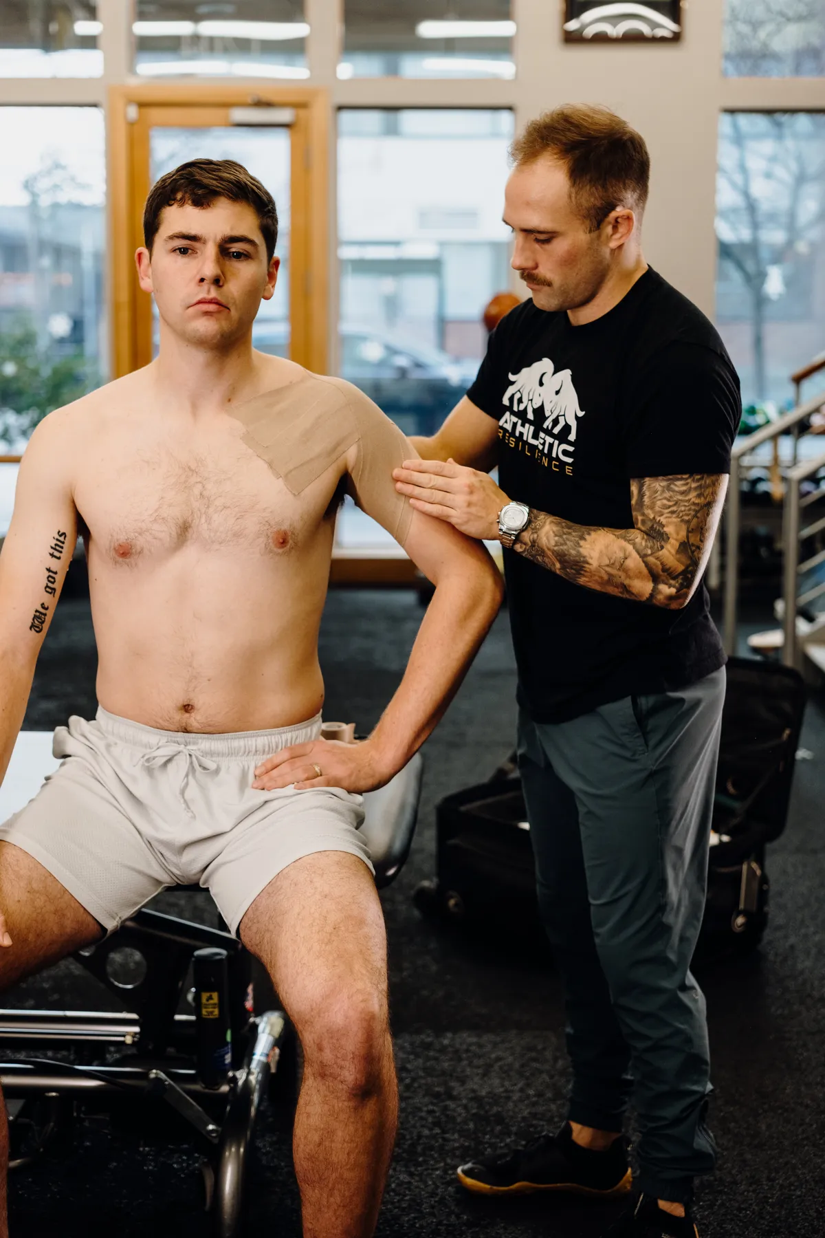 Practitioner applying kinesiology tape to an athlete's shoulder