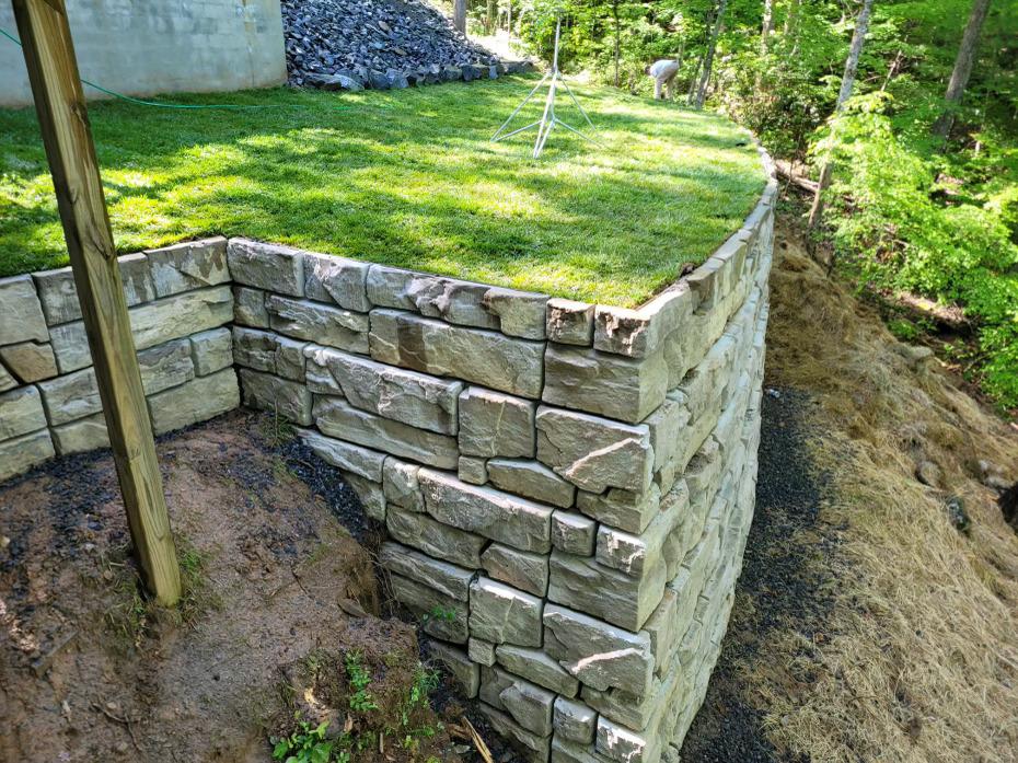 retaining wall installation with stacked stone blocks
