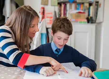 Teacher providing one-on-one reading tutoring to help a student improve literacy skills at iReading Tutor