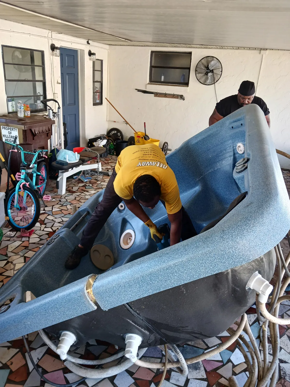 two-person crew removing hot tub