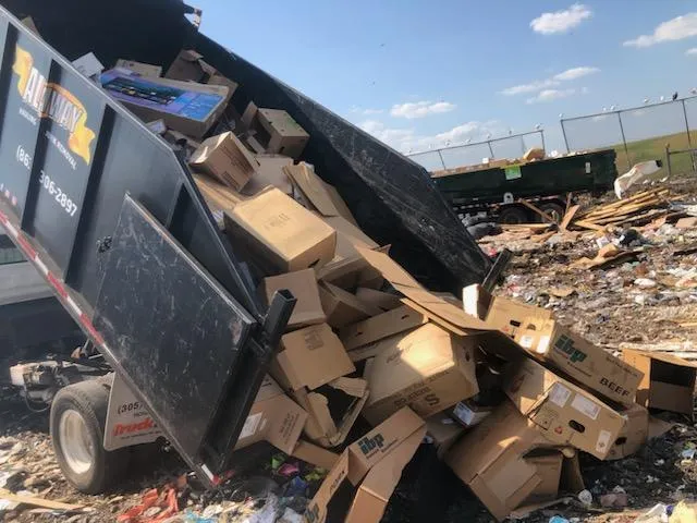 Dump druck emptying card board boxes at landfill